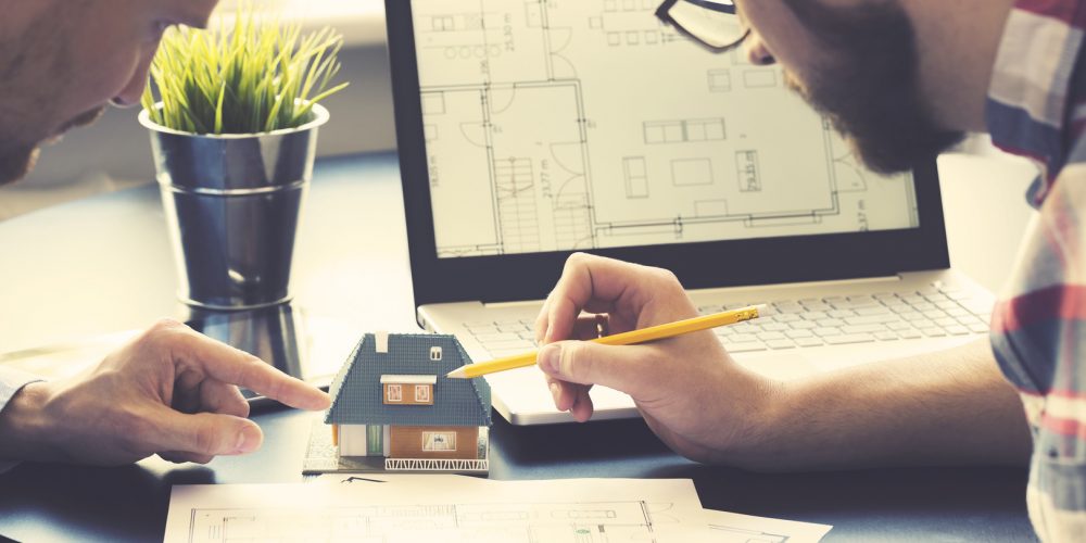 architect showing new family house model to customer at office